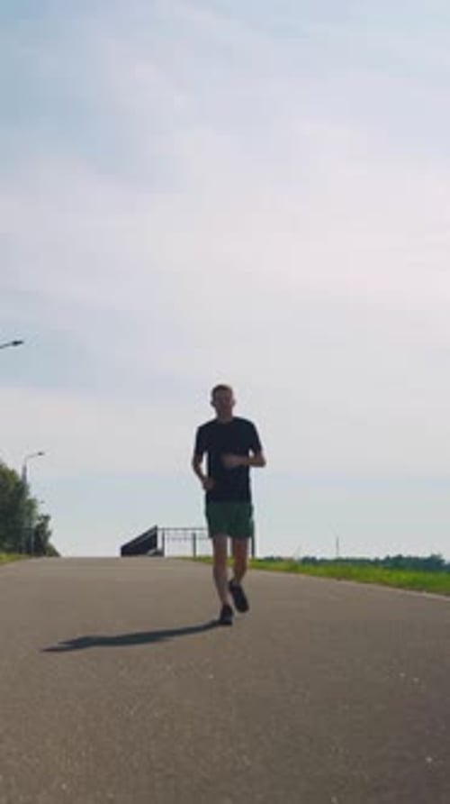 Man Jogging on Road in Daytime