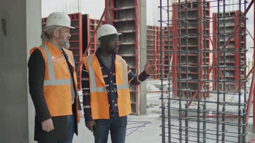 Un constructeur présente les résultats du coffrage au superviseur du chantier