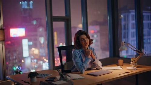 Woman Working at Desk in Office at Night
