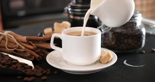 Pouring Milk into Cup of Coffee