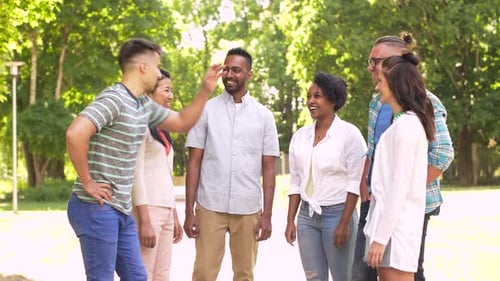 Unity, Friendship And International Concept - Group Of Happy Smiling Friends Stacking Hands In Park