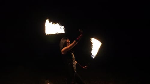 Woman Performing Fire Dancing at Nighttime Festival