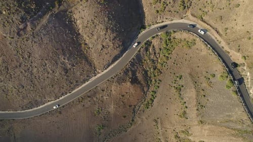 Cars are driving along the tiny Los Ajaches road, Lanzarote, Canary Island. Dry climate landscape du