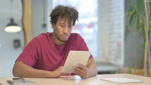 Young Adult Using Tablet in Brightly Lit Workplace