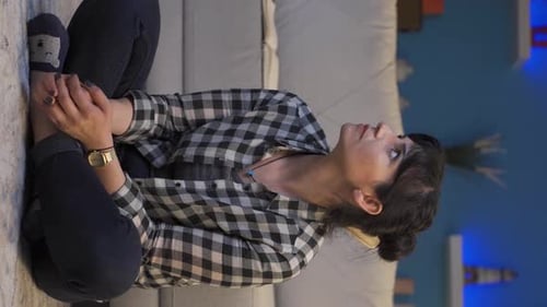 Woman Sitting on Floor Looking Thoughtfully to Side