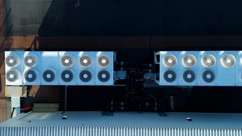 Top down drone view of rooftop HVAC maintenance, showcasing the grid layout of ventilation and air