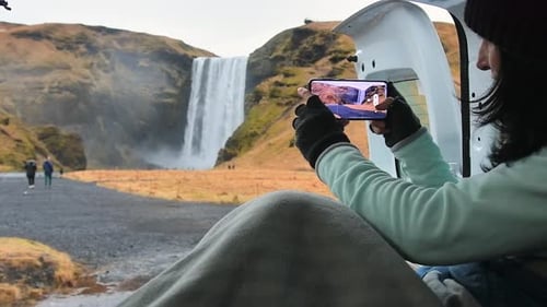 Woman Capturing Waterfall View from Inside Van