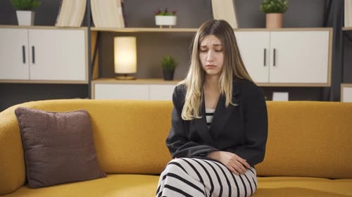 Worried Woman Sitting on a Couch Indoors