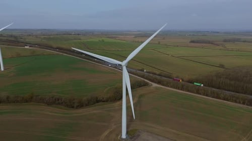Wind turbines rise above the rolling green fields, capturing clean energy from the open countryside