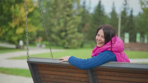 Relaxed Lady in Park Seat Female Enjoying Peaceful Moment on Wooden Swing Woman Seated on Park Swing