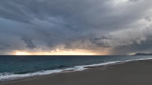 Dramatic Sunrise Over the Sea Waves and Rainy Beach Morning Stormy Clouds