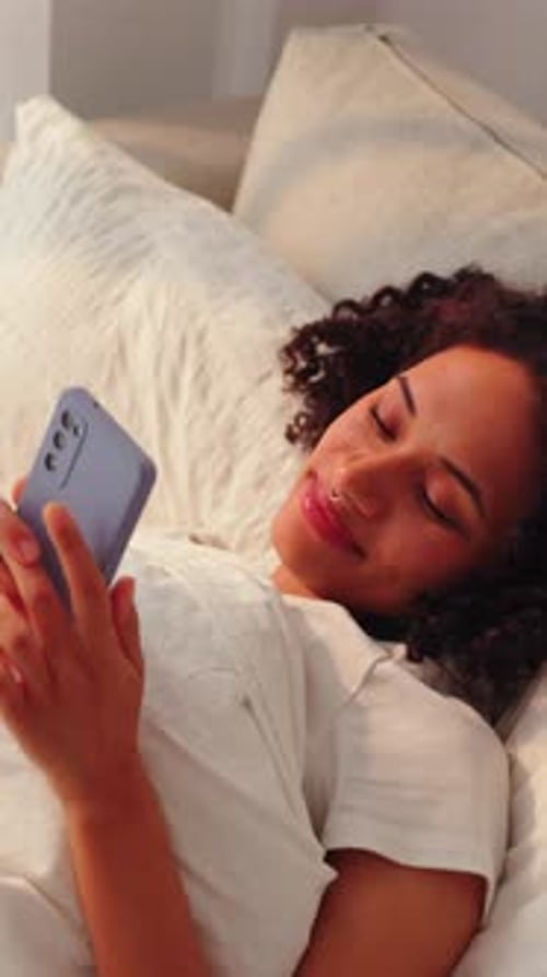 Woman Relaxing in Bed with Smartphone