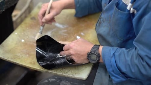 a craftsman handmade a shoe by painting, close up shot, insert shot