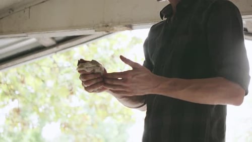 Mechanic Wiping Hands with Rag After Repairing Car Engine in Garage