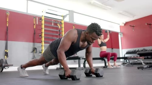 Fit African American man doing push-ups at the gym