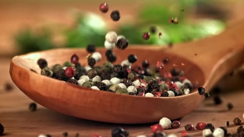 Falling Colorful Peppercorns in Wooden Spoon Close Up