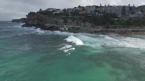 Waves Crashing On The Sea Wall Of Bronte Baths. Bronte Beach In Sydney, NSW, Australia. aerial sidew