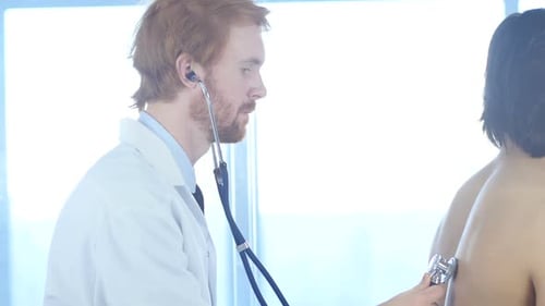 Doctor Examining Patient With Stethoscope in Clinic