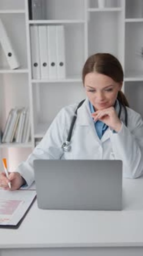 Woman Doctor Working at Desk with Laptop