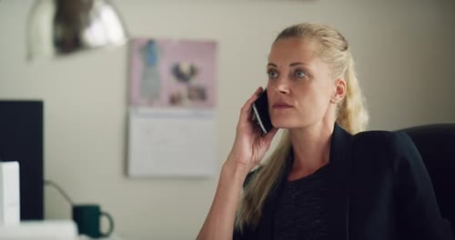 Blonde Business Woman Talks on Cell Phone in Office During the Daytime