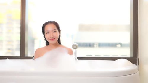 Gorgeous stoic asian beauty bubble bathing