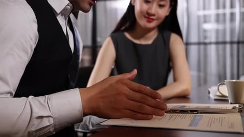 Professional business colleagues having work conversations in modern office, reviewing documents, di