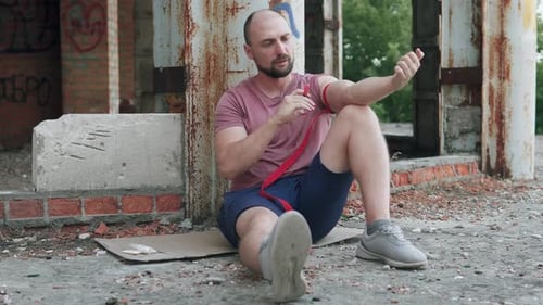 Bearded Man Sitting in Derelict Building