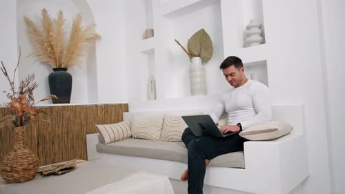 Young Adult Works on Laptop in Modern Home