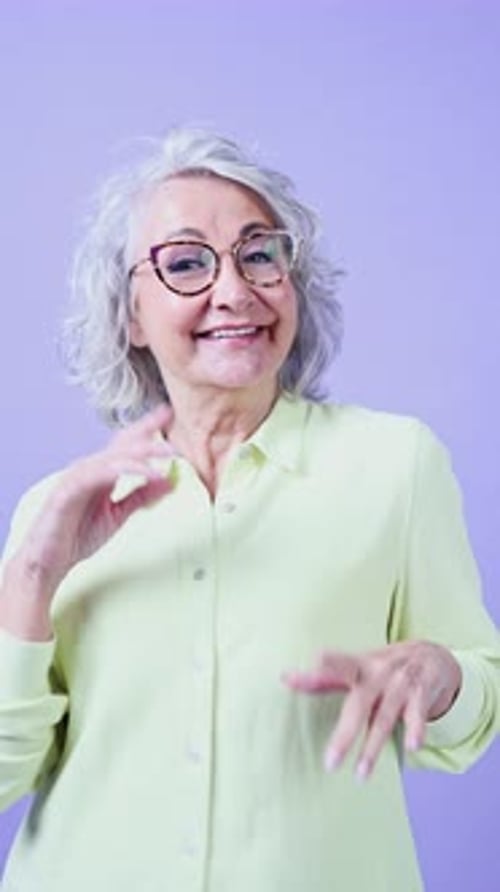 Joyful Senior Woman Dancing and Laughing in Studio