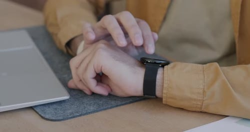 Man Using Smart Watch at Desk