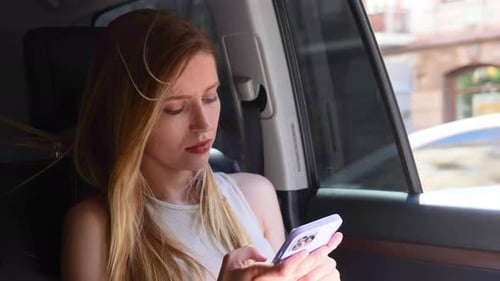 Woman Using Phone in Car on Sunny Day