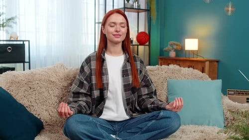 Relaxed Woman Meditating on Cozy Couch at Home