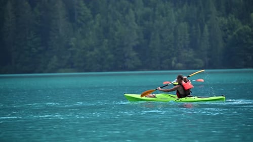 Man Kayaking on Beautiful Turquoise Lake