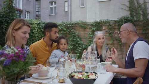 Family Enjoys Outdoor Meal Together in City Garden