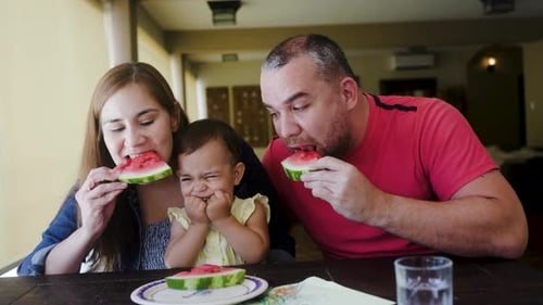 Family Eating Watermelon Together at Home