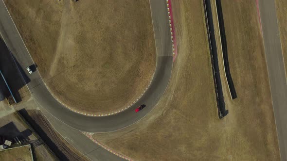 Rotational aerial view of racing cars turning at curve of racing track ...