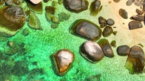 Stunning sandy beach with rock and clean sea water by aerial view. 4K.