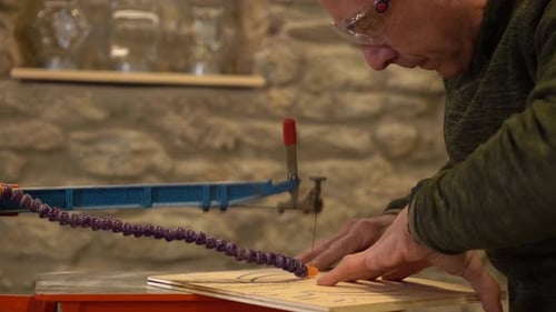 Elder expertise carpenter cutting wood in a workshop