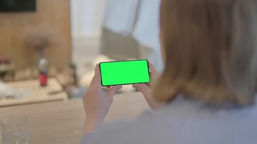 Young Woman Holding Phone with Chroma Key Screen