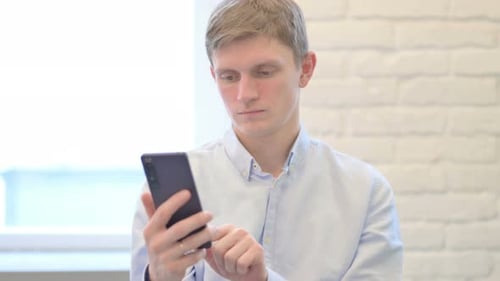 Young Businessman Using Smartphone, Browsing Internet