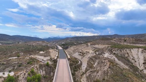 Aerial hazily drifts above an extraordinary abandoned landscape bisected by a long empty road to now