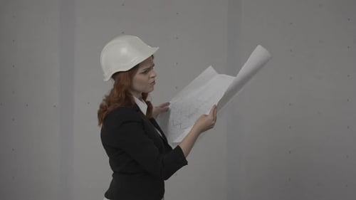 Side View of an Architect Woman Holding a Plan Drawing of a Building in Her Hands A Business Woman