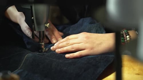 Gray Haired Person Sewing Dark Blue Denim Fabric