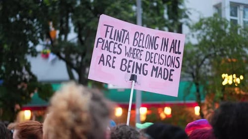 Crowd Protests at Rally with Handmade Sign