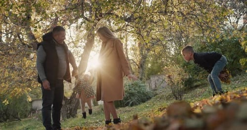 Family with Two Children Have Fun in Autumn Park