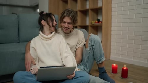 Affectionate Couple Using Laptop in Cozy Home