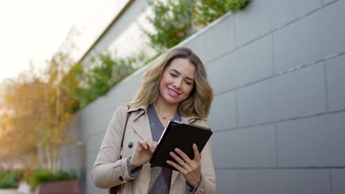Professional Businesswoman Using Tablet While Walking Outdoors