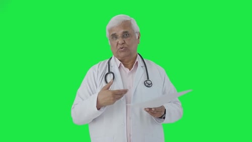 Indian senior doctor explaining health reports to the patient Green screen
