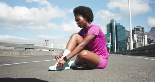 Athlete, woman and tie shoes in city for getting ready, fitness preparation and exercise