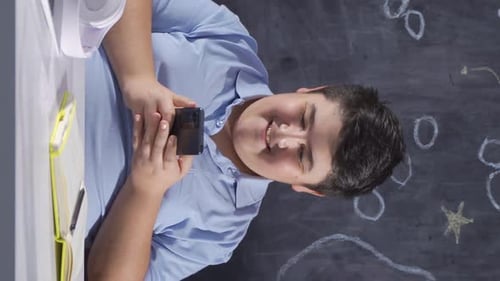 Student Using Mobile Phone at Desk in Classroom